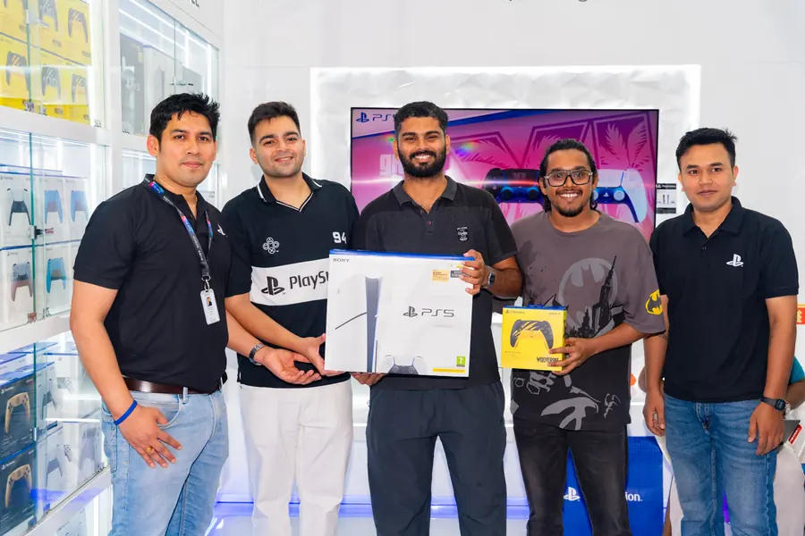 Store team and a customer holding a PS5 console box and a limited edition controller
